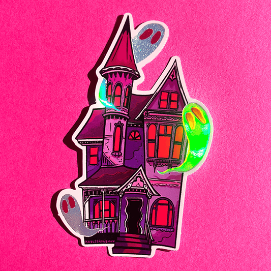 A die-cut sticker featuring a stylized haunted house with glowing neon green and silver ghosts, shown on a textured hot pink background.