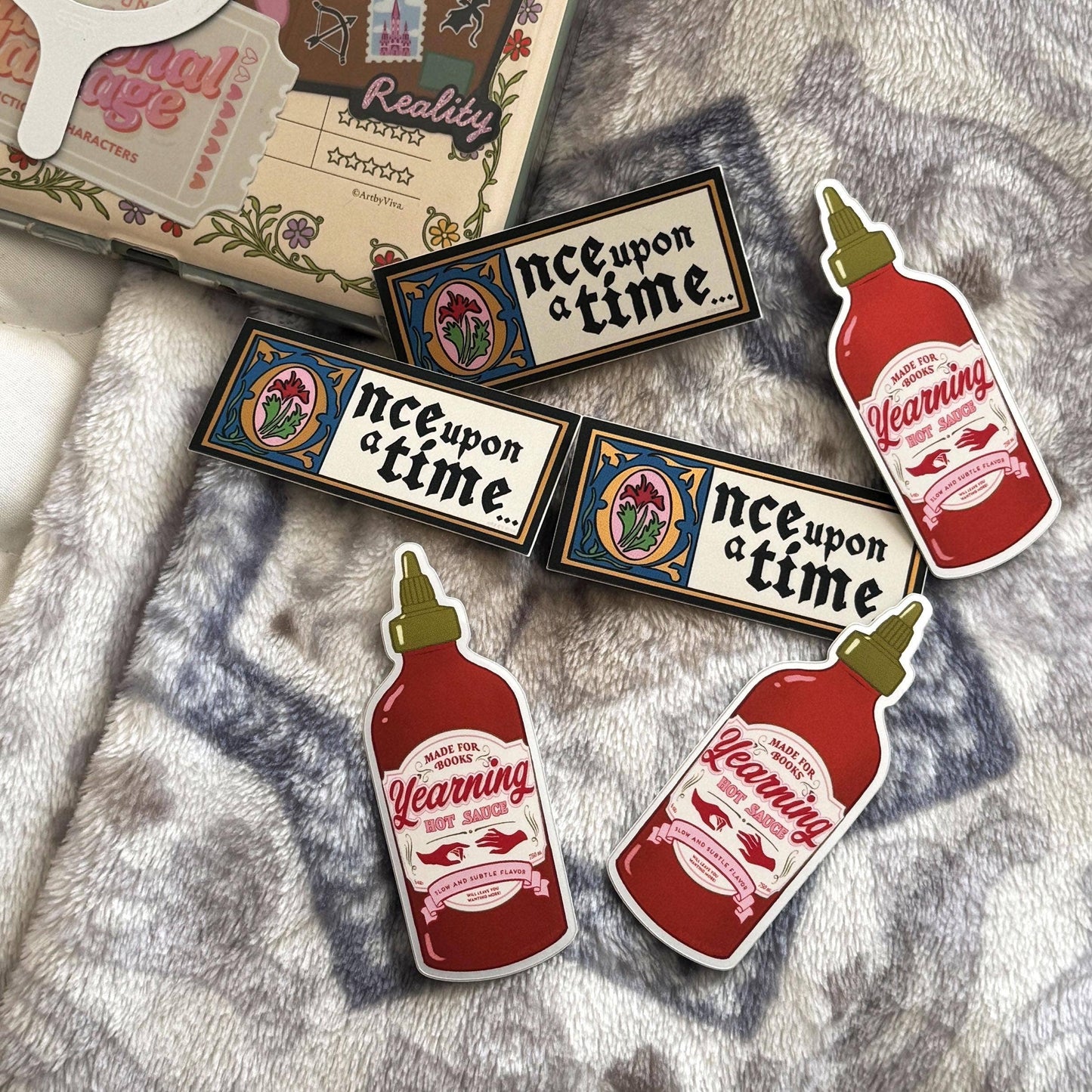 Stickers with 'Once Upon a Time' and 'Warning Hot Sauce' designs on a textured surface.