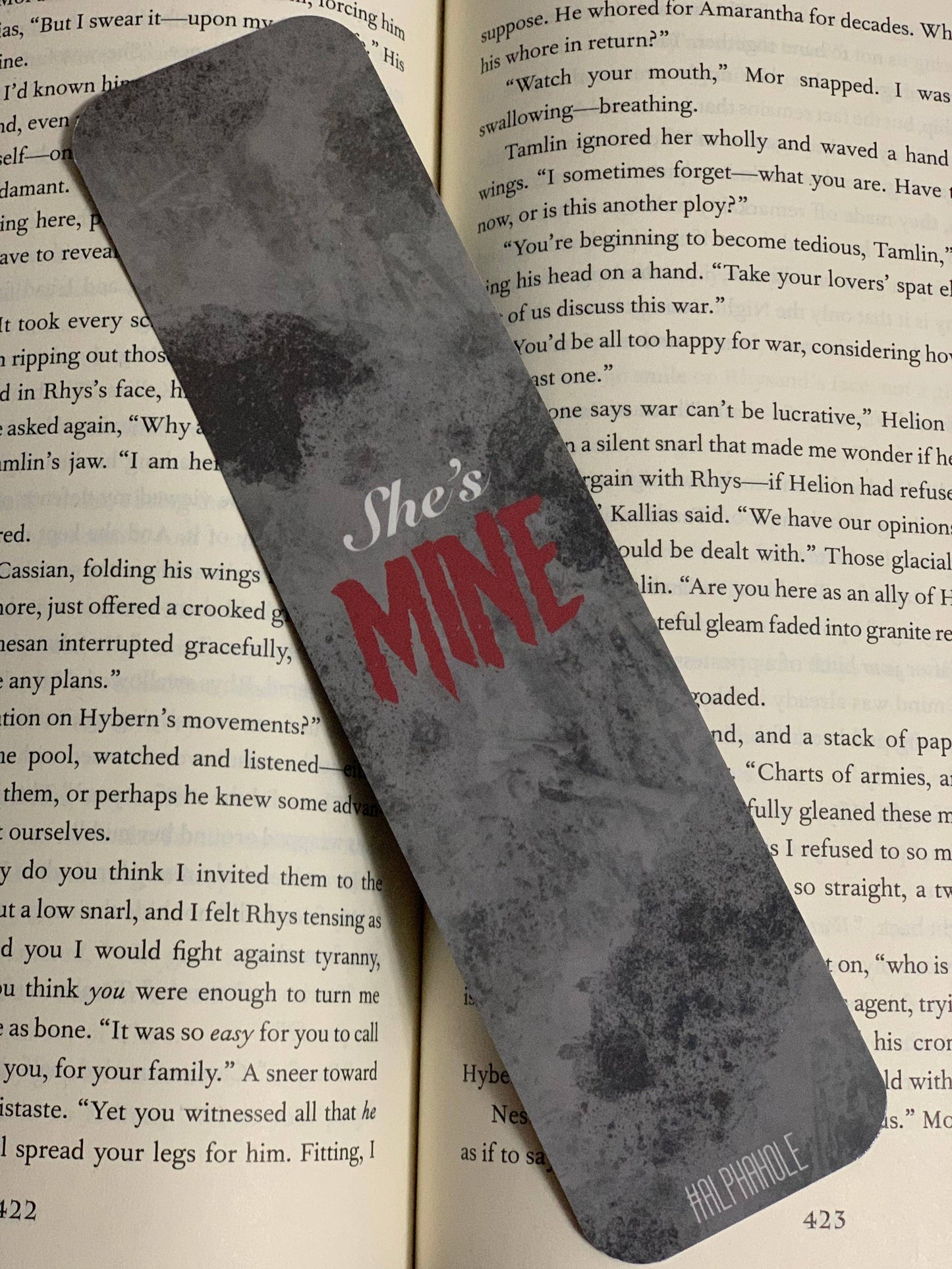 Metallic bookmark with 'She's Mine' text on an open book