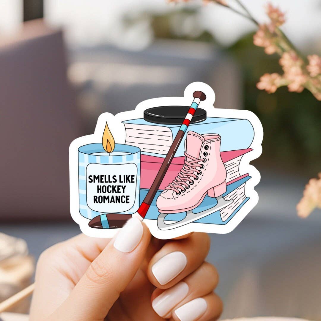 Sticker with hockey-themed design held by a hand, with a blurred background.