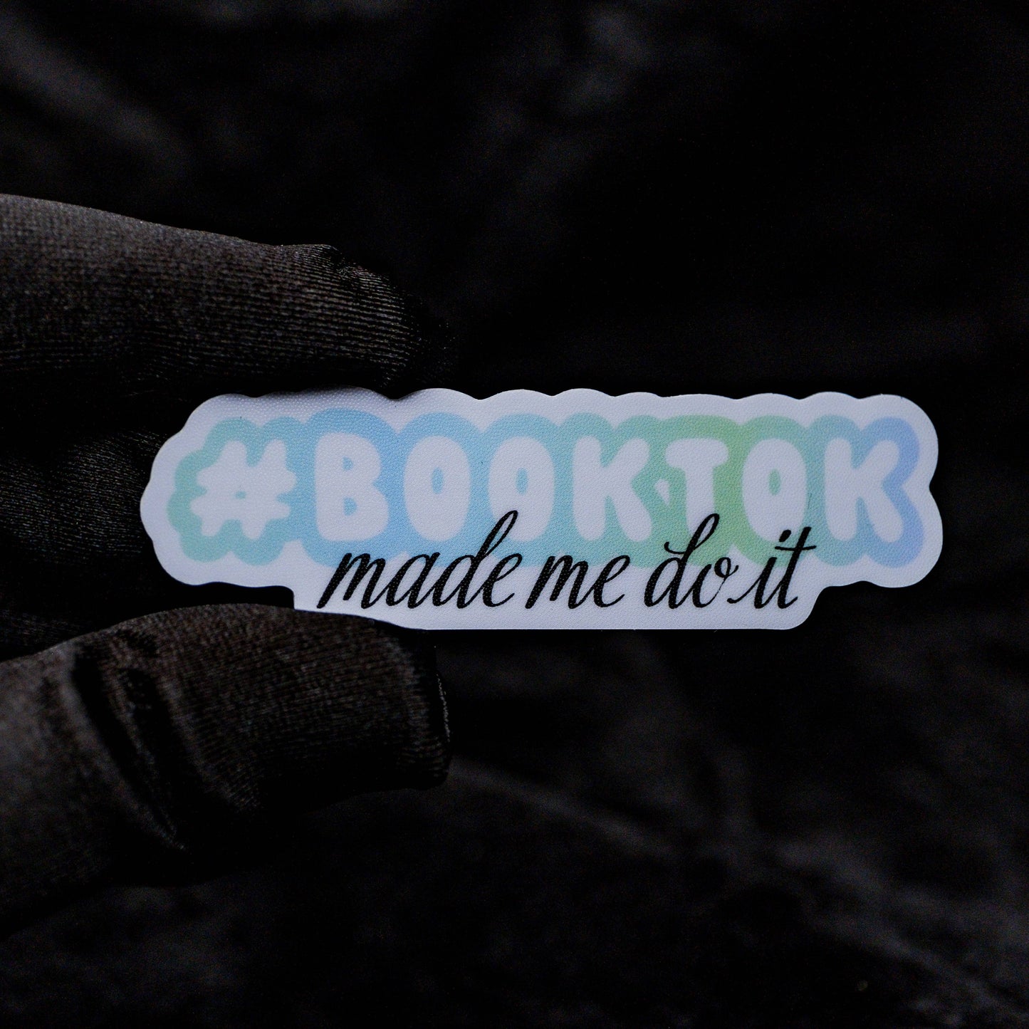Sticker with '#booktok made me do it' text on a dark background