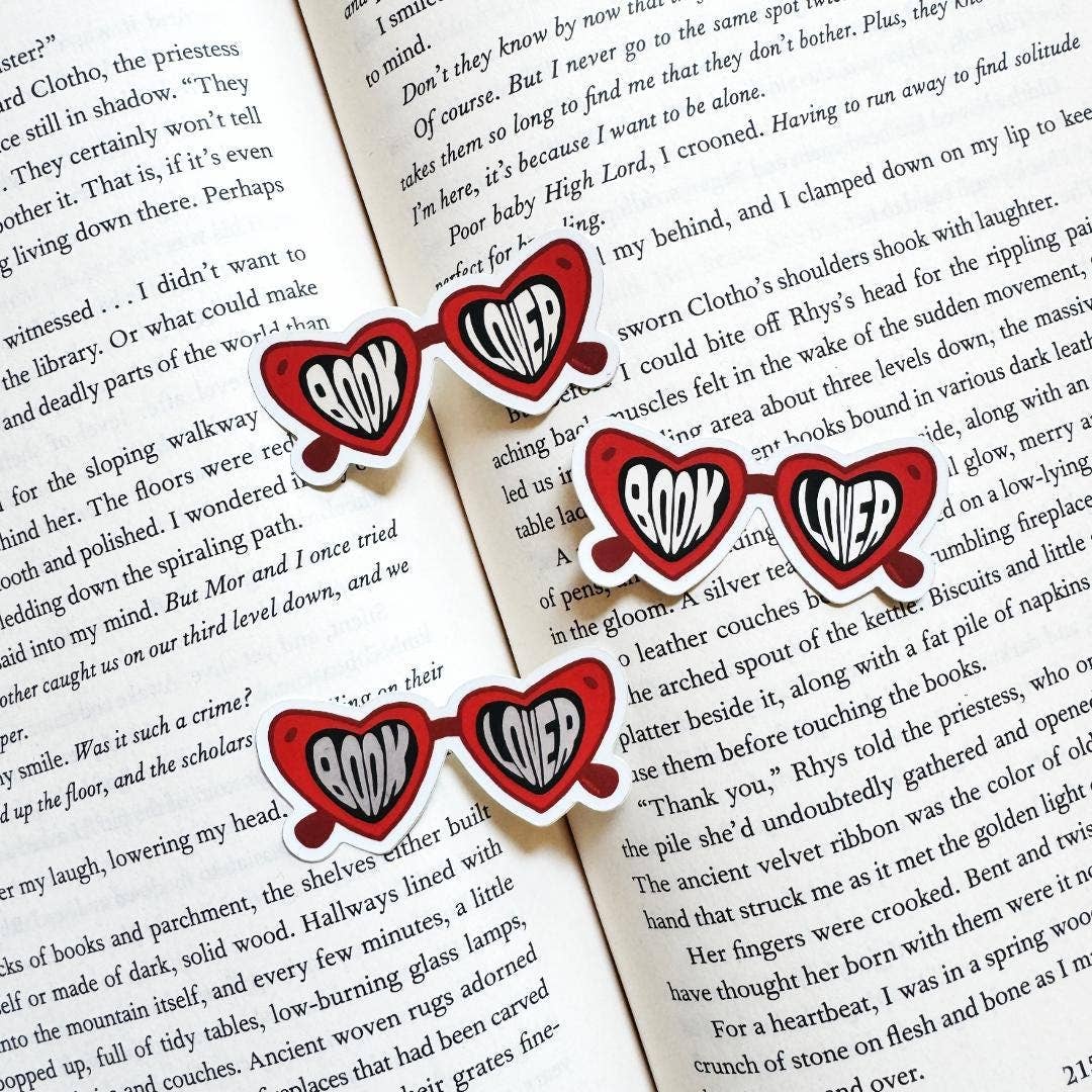 Red heart-shaped earrings with 'LOVE' text on a book page