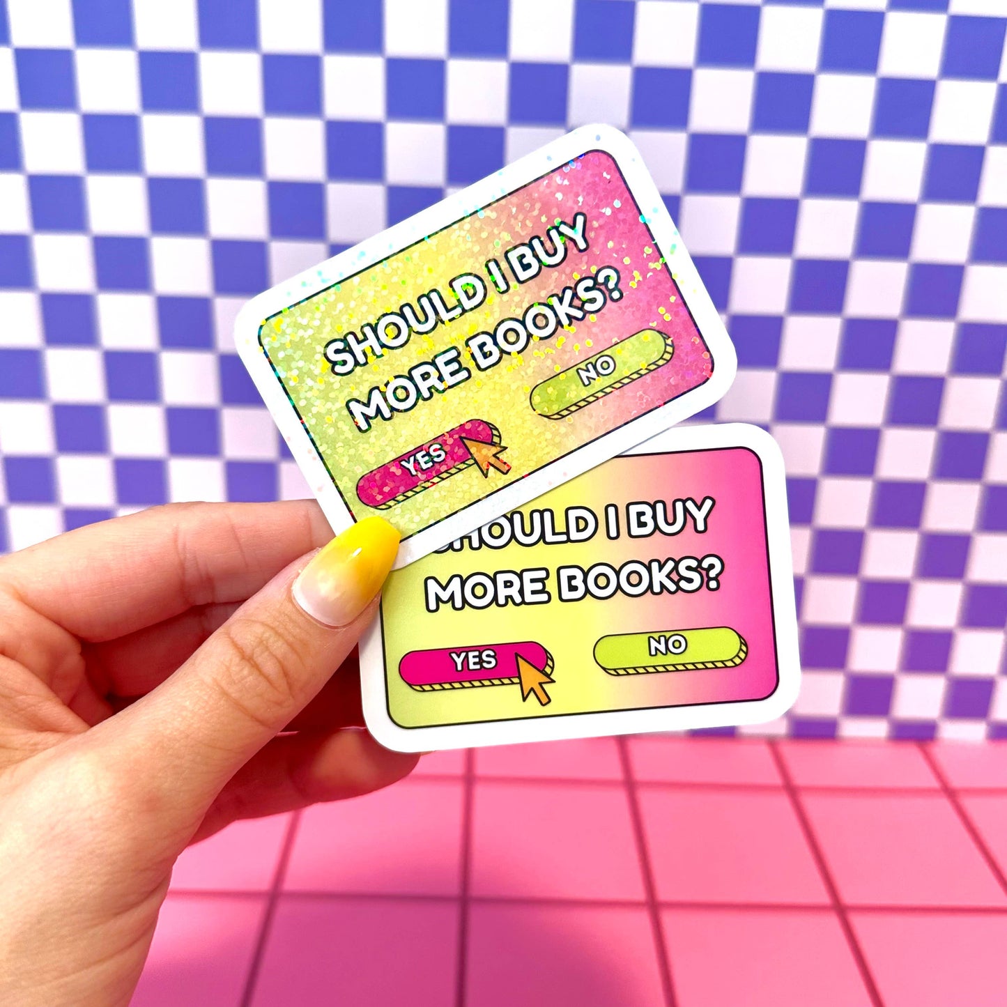 Two colorful cards with text 'Should I buy more books?' held against a checkered background.