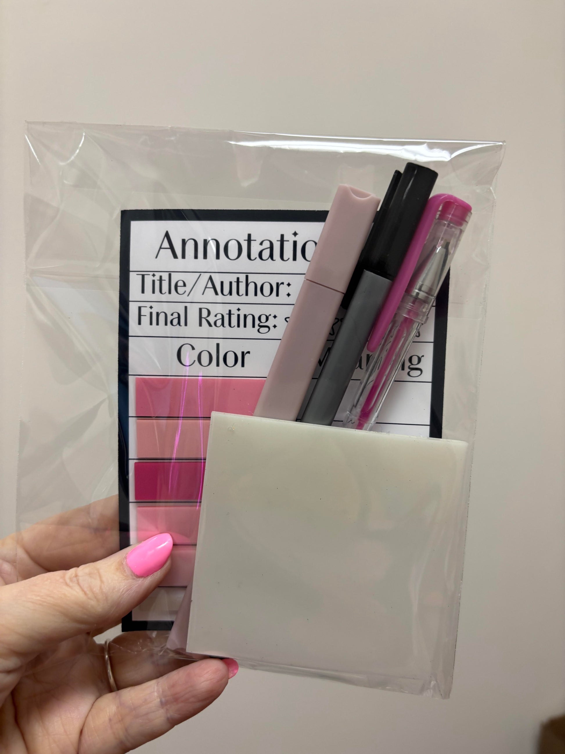 Hand holding a clear plastic bag with stationery items and rating scale.
